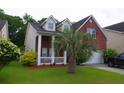 Two-story home featuring brick and siding, complemented by a lush green lawn and palm tree at 1757 Wayah Dr, Charleston, SC 29414