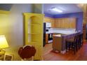 Open kitchen featuring wooden cabinets, breakfast bar, and hardwood floors with a yellow corner shelf nearby at 1757 Wayah Dr, Charleston, SC 29414