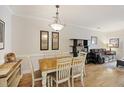 Dining room with a wooden table with seating for six highlighted by a decorative light fixture at 1984 Folly Rd # A307, Charleston, SC 29412