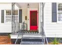 Close-up of the front door with a bright red finish, black hardware and striped welcome mat at 205 Tea Farm Rd, Summerville, SC 29483