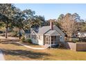 Beautiful home featuring a cozy screened porch, gray shingles, light yellow siding, and a brick chimney at 2178 Fort Pemberton Dr, Charleston, SC 29412