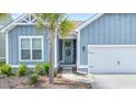 Front entry with a blue door, an adjacent garage, and a nicely landscaped flower bed at 221 Seaworthy St, Summerville, SC 29486