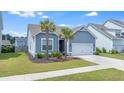 Charming single-Gathering home with two palm trees, an attached two-car garage, and beautiful blue siding at 221 Seaworthy St, Summerville, SC 29486