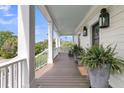 Inviting porch featuring classic white columns, decorative lanterns, and scenic views, perfect for relaxing at 2269 Hartfords Bluff Cir, Mount Pleasant, SC 29466