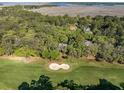 An aerial shot of a lush golf course neighborhood, complete with sand traps and surrounding marshland at 2355 Andell Way, Seabrook Island, SC 29455