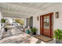 Inviting front porch with comfortable seating and a stylish wood front door at 2802 Ion Ave, Sullivans Island, SC 29482