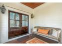 Inviting front porch with double doors, a wooden bench, throw pillows, and decorative lanterns at 3 37Th Ave, Isle of Palms, SC 29451