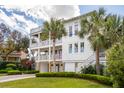 Charming three-story home with multiple balconies, palm trees, and a well-maintained green lawn at 3 37Th Ave, Isle of Palms, SC 29451