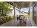 Covered porch with seating arrangement and view of a lush backyard and white picket fence at 308 Scholar Way, Summerville, SC 29486