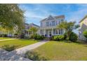 Attractive two-story home featuring a lovely front porch and lush green lawn at 311 Amaryllis Ave, Summerville, SC 29483