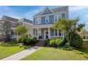 Inviting two-story home with a classic front porch and beautifully maintained lawn at 311 Amaryllis Ave, Summerville, SC 29483