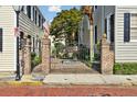 Elegant brick and iron gate providing access to a courtyard garden at 32 Church St, Charleston, SC 29401