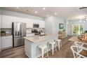 Modern kitchen with stainless steel appliances, granite countertops, and an island with seating, connecting to the living area at 325 Pine Crest View, Summerville, SC 29486
