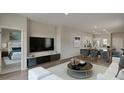 Inviting open-concept living area with a modern entertainment center and seamless flow to the dining and kitchen at 331 Pine Crest View, Summerville, SC 29486