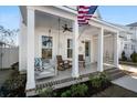 Cozy front porch featuring a swing, rocking chairs, and patriotic decor, ideal for unwinding at 371 Ripple Park Dr, Summerville, SC 29486