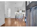 Open-concept living space showcasing hardwood floors and a modern kitchen beyond the dark wood front door at 4 Addison St, Charleston, SC 29403