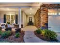 Charming front entrance with stone accents, manicured landscaping, and an inviting porch with rocking chairs at 440 Four Seasons Blvd, Summerville, SC 29486