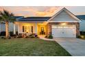 Exterior of a charming single-Gathering home with a stone facade, well-kept lawn, and a cozy front porch at dusk at 440 Four Seasons Blvd, Summerville, SC 29486