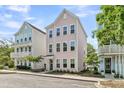 Charming three-story home with a pastel pink exterior and manicured front yard with healthy lawn at 4429 Avery Ave, North Charleston, SC 29405