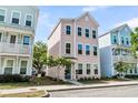 Charming three-story home with a pastel pink exterior and manicured front yard in suburban setting at 4429 Avery Ave, North Charleston, SC 29405
