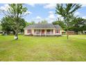 Charming one-story home featuring a welcoming front porch, vibrant red shutters and lush front lawn at 449 Mary Lou Ln, Moncks Corner, SC 29461