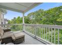 Relaxing covered balcony with comfortable seating and a scenic view of lush greenery at 45 Sycamore Ave # 1532, Charleston, SC 29407