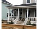 Inviting front porch view with dogs sitting on stairs of charming home featuring white columns and bright blue door at 5153 Celtic Dr, North Charleston, SC 29405