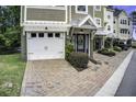 Beautiful townhome featuring a brick driveway and attached garage with well-maintained landscaping at 5911 Steward St # 24, Hanahan, SC 29410