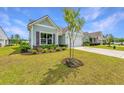 Inviting home with landscaped front yard, charming details, and a well-maintained lawn at 6176 Wilkes Pond Dr, Hollywood, SC 29449