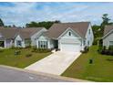 Well-maintained home with manicured front lawn and a convenient two-car garage and spacious driveway at 6176 Wilkes Pond Dr, Hollywood, SC 29449