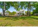 Spacious backyard featuring a well-maintained lawn, mature trees, and an outdoor deck area at 679 Clearview Dr, Charleston, SC 29412