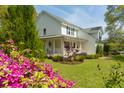 Well-maintained two story home featuring a covered porch, manicured lawn, and colorful azalea bushes at 679 Clearview Dr, Charleston, SC 29412