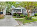 Lovely single-story home with a well-maintained yard and a covered front porch at 71 Cypress St, Charleston, SC 29403
