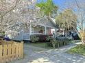 Inviting one-story home with a welcoming porch framed by a blooming tree at 71 Cypress St, Charleston, SC 29403