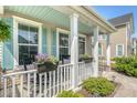 Inviting front porch with rocking chairs, flower boxes, and a beadboard ceiling, perfect for enjoying relaxing moments outdoors at 7414 Purser Ln, Hanahan, SC 29410