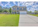 Two-story house with green shutters, a well-manicured lawn, and a long driveway at 7477 Painted Bunting Way, Hanahan, SC 29410