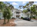 A bright, multi-story condo complex with mature trees and convenient parking in front at 856 Club Cottage Rd, Edisto Beach, SC 29438