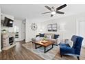 A stylish living room with gray walls, wood floors, modern furniture, and a decorative fireplace at 856 Club Cottage Rd, Edisto Beach, SC 29438