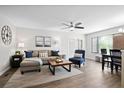 A well lit living room with modern decor, a ceiling fan, and access to the dining area at 856 Club Cottage Rd, Edisto Beach, SC 29438