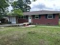 View of the front yard with a single story brick house with green shutters at 10 Cranford Rd, Goose Creek, SC 29445