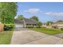 Suburban home with a large driveway, attached garage, and inviting front porch at 102 Bristol Ln, Goose Creek, SC 29445