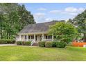 Charming home featuring a covered porch with white railings and meticulously kept landscaping at 102 Bristol Ln, Goose Creek, SC 29445