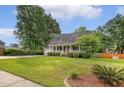 Lovely home with a well-manicured front lawn and cozy porch with verdant surroundings at 102 Bristol Ln, Goose Creek, SC 29445