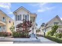 Charming two-story home with a covered porch, beautiful landscaping, and a driveway at 103 Fishburne St, Charleston, SC 29403