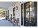 Inviting front porch features a dark front door, a seating bench, and outdoor lighting at 103 Fishburne St, Charleston, SC 29403