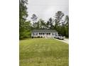 A lovely ranch-style home features a gray exterior, dark shutters, and a spacious front yard at 110 Kay St, Ridgeville, SC 29472