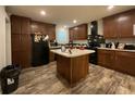 Well-appointed kitchen featuring dark wood cabinets, a central island, and modern black appliances at 110 Kay St, Ridgeville, SC 29472