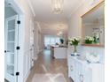 Elegant entryway featuring a hardwood floor, white wainscotting and a view to the kitchen at 1100 Saltwater Cir, Johns Island, SC 29455