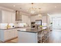 Modern kitchen with white cabinets, a stainless steel hood, and a large island with counter seating at 1100 Saltwater Cir, Johns Island, SC 29455