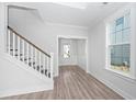 Bright entryway featuring wood-look flooring, staircase with white risers and modern railing, and trim package at 111 Sawlog Dr, Summerville, SC 29486